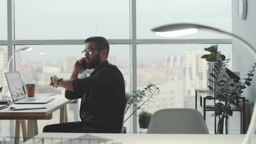 Young Man Having Phone Talk at Work in Modern Office