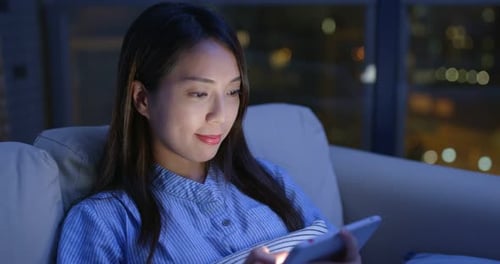 Woman Uses Mobile Tablet at Night in City Home