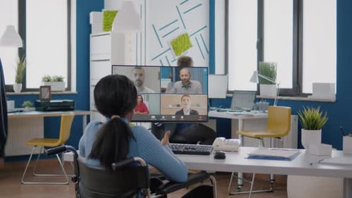 Person in Wheelchair Attends Virtual Meeting in Office