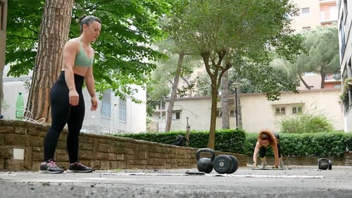 Two Women Doing Pushups Outdoors