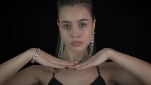 Elegant Woman with Silver Jewelry Posing on Black