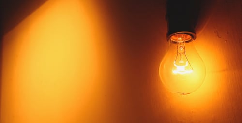 Glowing Lightbulb Flickering in Dark Room