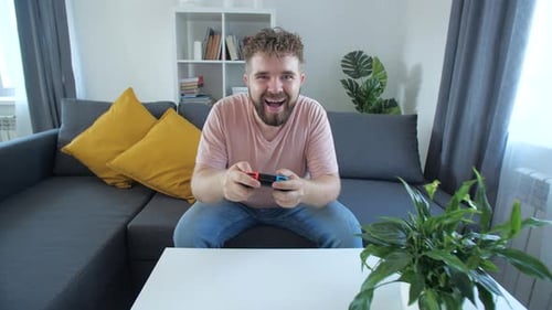 Excited Man Playing Video Games at Home