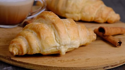 Golden Croissants with Coffee and Cinnamon Sticks