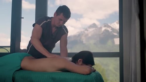 Chiropractor is Massaging Back of Female Patient in Medical Center