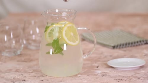 Lemonade with Lemon and Mint Being Stirred