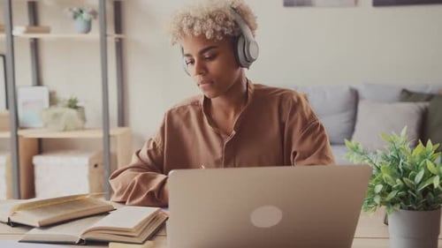 Young Adult Studies at Home with Laptop and Books