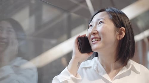 Smiling Woman Talking on Cell Phone Indoors