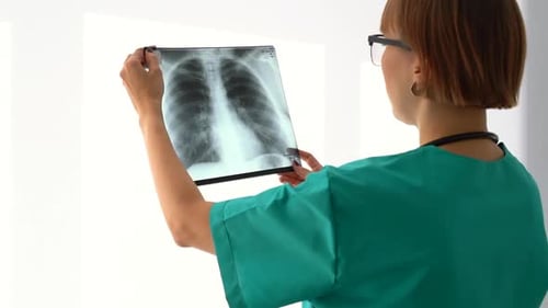 Doctor Analyzing Lung X-Ray in Hospital Setting