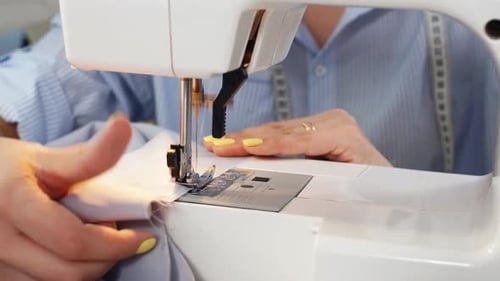 Close-up of a Woman's Hand Dressmaker Working on a Sewing Machine in Her Studio