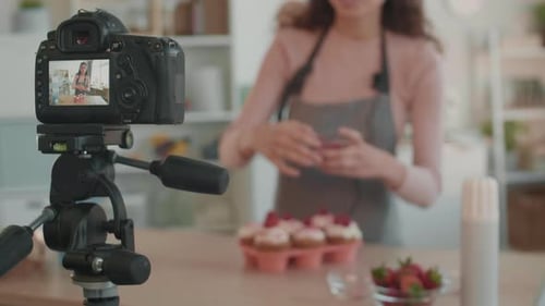 Woman Decorates Cupcakes While Recording a Vlog