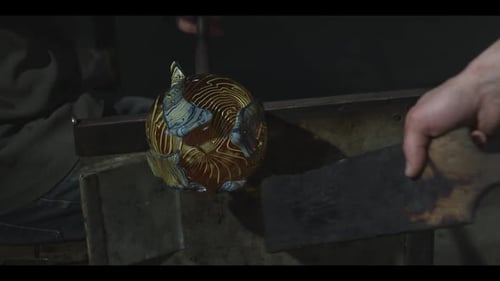 Glassblower Shaping Molten Glass in Workshop