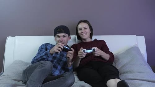 Young Adult and Woman Play Video Game at Home