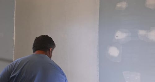 Man Painting Interior Wall with Paint Roller