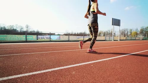 Young Athletic Woman Running on Stadium Track