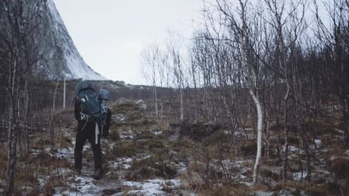 Hiker Walking Up Hill With Snow