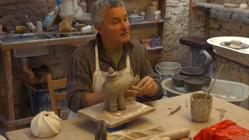 Craftsman Making a Clay Sculpture in Pottery Workshop