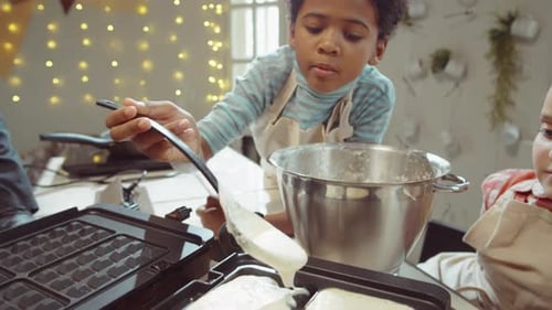 Boy Making Waffles with a Spoon