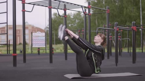 Femme athlétique faisant des craquements avec les orteils pendant l'entraînement en plein air