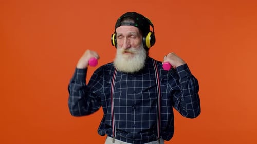 Energetic Senior Man Lifting Weights With Headphones