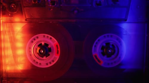 Vintage Cassette Tape Reels Spinning in Red and Blue Lights
