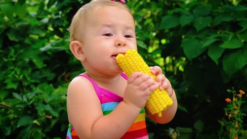 The Child Eats Corn on the Street