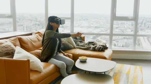 Woman Exploring Virtual Reality on Sofa at Home