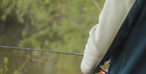 Man Fishing by River in Nature Setting