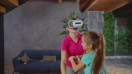 Woman Using VR Goggles with Young Girl Indoors