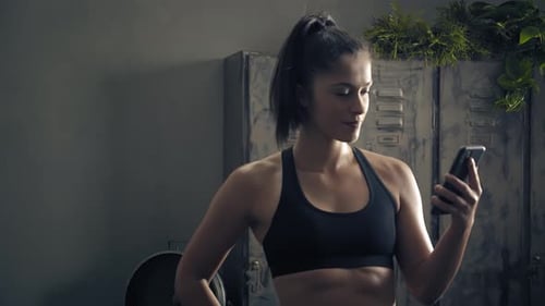 Young Woman Using Smartphone in Gym Environment