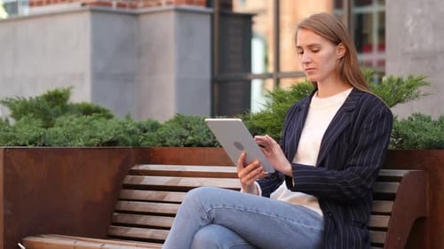 Woman Using Tablet Outside in City