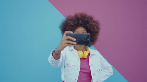 Smiling Woman Takes Selfie Against Colorful Background