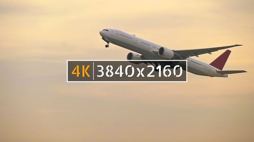 Airplane Ascending into the Orange Sunset Sky