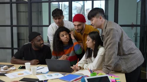 Young Professionals Collaborating Around Laptop in Modern Office