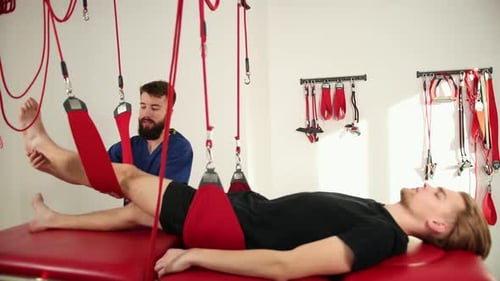 Therapist Assisting Man with Leg Stretching Exercise