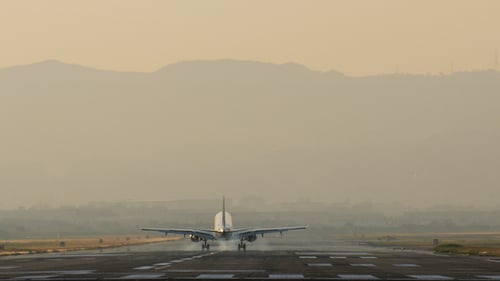 Passenger Plane Lands on Airport Runway at Sunset