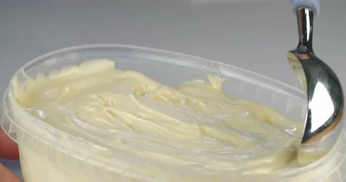 Ice cream scoop scooping mango flavored soft ice cream