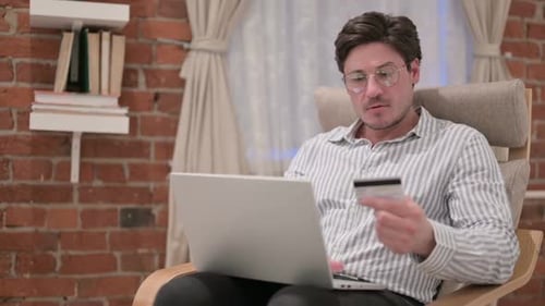 Man Frustrated with Online Shopping on Laptop at Home