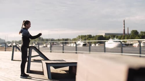 Woman Exercising by Waterfront Doing Step-Ups