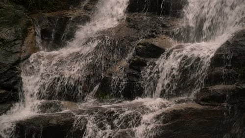 Fresh Waterfall Flowing Down Dark Rocks