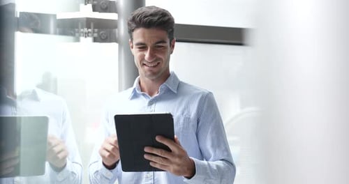 Smiling Man Using Tablet Device in Modern Office
