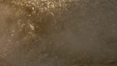 Truck unloading gravel on road construction site