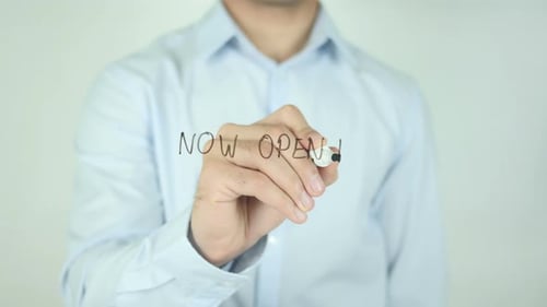 Man Writes "Now Open!" on Clear Surface