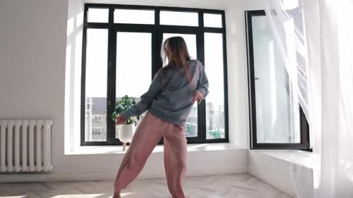 Street Dancing Young Pretty Woman in Blue Sweater Dances in Spacious Room By the Windows