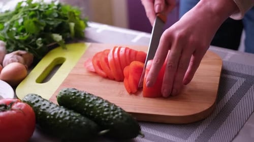 Hands Slicing Fresh Tomato in Kitchen Close Up