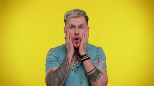 Man Reacts in Shock on Yellow Background