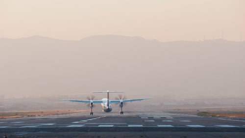 Propeller Plane Landing on Runway at Sunrise