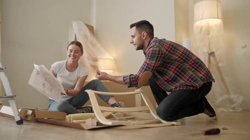 Young Adults Moving in New Home, Couple Moving in Assembling Chair Furniture, Young Interracial