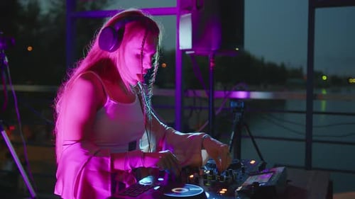 Female DJ Mixing Music at Night