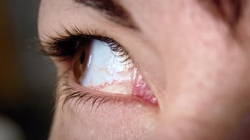 Cinématographique : œil de femme regardant autour de lui et dans la caméra, prise de vue macro, œil brun féminin